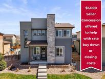 Inviting front exterior showcasing a two-story home with a stone accent wall and landscaped front yard at 10062 Southlawn Cir, Commerce City, CO 80022