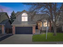 Charming two-story home featuring a brick facade, well-maintained lawn, and an attached two-car garage at 96 S Lindsey St, Castle Rock, CO 80104