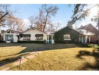 Charming home featuring a manicured lawn, mature trees, and an ivy-covered exterior at 1602 Glen Bar Dr, Lakewood, CO 80215