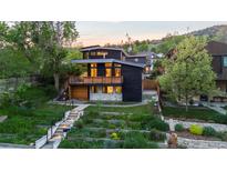 Modern two-story home with a wood balcony, stylish architecture, and tiered landscaping at 2725 6Th St, Boulder, CO 80304