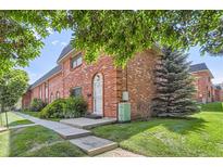 Charming brick townhome featuring a well-manicured lawn and mature landscaping, creating inviting curb appeal at 3659 W Union Ave, Denver, CO 80236