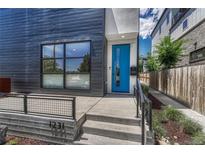 Modern home featuring a sleek exterior, a vibrant blue front door, and manicured landscaping at 1231 Newton St, Denver, CO 80204
