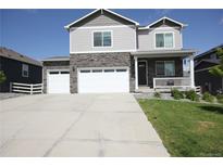 Charming two-story home featuring stone accents, a large driveway, and a welcoming front porch at 4955 Trails Edge Ln, Castle Rock, CO 80104
