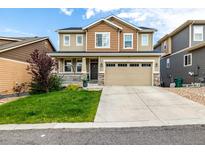 Charming two-story home featuring a well-manicured lawn and inviting front porch at 21271 E Smoky Hill Rd, Centennial, CO 80015