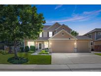 Charming two-story home features a well-manicured lawn, mature tree and a three car garage at 12000 Pine Top St, Parker, CO 80138