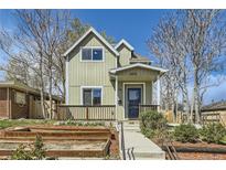 Charming two-story home featuring a cozy front porch and landscaped garden at 3225 Olive St, Denver, CO 80207