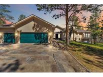 Stunning home featuring a green garage door, stone driveway, and mature trees at 1653 Gore Dr, Larkspur, CO 80118
