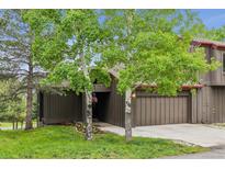 Charming exterior featuring mature trees, attached garage, and a welcoming entrance perfect for mountain living at 24036 Currant Dr, Golden, CO 80401