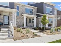 Stylish townhome featuring stone accents, well-maintained landscaping, and a welcoming covered entryway at 762 N Rome St, Aurora, CO 80018