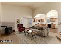 Bright, staged living room featuring a fireplace, open archways to the kitchen, and neutral decor at 250 Upper Forest Rd, Idaho Springs, CO 80452
