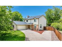 Beautiful two-story home with an attached garage, lush lawn, and a long driveway on a sunny day at 4571 S Memphis St, Aurora, CO 80015