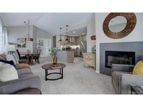 Open-concept living space with a fireplace, dining area, and kitchen featuring modern finishes and abundant natural light at 6283 Kilmer Loop # 201, Golden, CO 80403