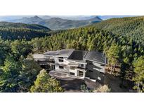 Stunning modern home nestled amongst a lush green forest with breathtaking mountain views in the distance at 13415 S Resort Dr, Conifer, CO 80433