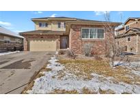 Charming two-story home features a brick and siding exterior, attached garage, and a well-maintained front yard at 247 N Coolidge Way, Aurora, CO 80018