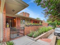 Charming brick home with a gated entrance and beautiful flower boxes, offering a warm and inviting curb appeal at 3481 S Race St, Englewood, CO 80113