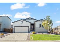 Charming single-story home with a well-manicured lawn and attached two-car garage at 1868 Homestead Dr, Fort Lupton, CO 80621