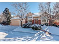 Beautiful two-story home with snow-covered landscaping and attached garage at 3016 Greensborough Dr, Highlands Ranch, CO 80129