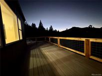 Enjoy this spacious deck with beautiful mountain views at twilight, perfect for outdoor entertaining at 33884 Bergen View Trl, Evergreen, CO 80439