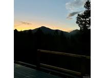 Breathtaking mountain sunset view from deck with silhouetted trees and fading sky at 33884 Bergen View Trl, Evergreen, CO 80439