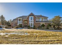 Brick two-story house with a large front yard and driveway at 5100 S Monaco St, Greenwood Village, CO 80111