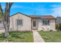 Charming single-story home featuring a well-maintained lawn and inviting front porch with two white chairs at 2235 W 46Th Ave, Denver, CO 80211