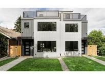 Modern townhomes with rooftop decks, white and gray exteriors and well-manicured lawns at 1541 Glencoe St, Denver, CO 80220