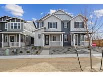 Charming townhome featuring a covered front porch and contemporary gray and white exterior at 1242 Penner Dr, Erie, CO 80026
