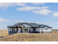Stunning single-story home with white siding, dark trim, and a stone foundation on a large lot at 5424 Freddys Trl, Parker, CO 80134
