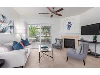 Bright living room featuring a ceiling fan, fireplace, and sliding glass doors to a balcony at 8200 E 8Th Ave # 8101, Denver, CO 80230