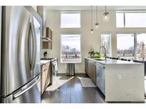 Bright kitchen featuring stainless steel appliances, quartz countertops, and modern wood cabinetry at 1616 S Broadway # 309, Denver, CO 80210