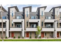 Modern townhome exterior featuring gray siding, brick accents, balconies, and vibrant orange front doors at 3308 W 17Th Ave, Denver, CO 80204