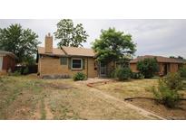 Charming single-story brick home featuring a well-maintained lawn and mature trees at 3301 Bellaire St, Denver, CO 80207