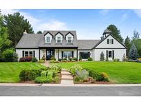 Charming home with well-manicured lawn and inviting curb appeal on a sunny day at 5698 Green Oaks Dr, Greenwood Village, CO 80121
