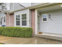 Charming front entrance featuring brick accents, a welcoming door mat, and well-maintained landscaping at 5404 W Canyon Trl # C, Littleton, CO 80128