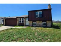 Charming home with a brick and wood exterior, complemented by a well-manicured front yard and an attached two car garage at 275 Mckinley Dr, Bennett, CO 80102