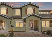 Inviting two-story townhome with a covered porch and warm sunset sky at 6916 Crestop Pl # F, Parker, CO 80138