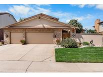 Charming home featuring a stone facade, two-car garage, and beautifully landscaped front yard in a great neighborhood at 11241 E Cimmarron Dr, Englewood, CO 80111