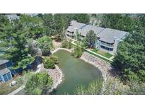 Aerial view of a condo community with a small pond and lush landscaping at 8600 E Alameda Ave # 17-203, Denver, CO 80247