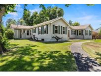 Charming home with green shutters, mature trees, and a well-manicured lawn, perfect for outdoor enjoyment at 7750 W 5Th Ave, Lakewood, CO 80226