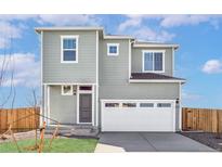 Charming two-story home featuring a front-facing garage, and a well-maintained lawn at 9474 Yampa St, Commerce City, CO 80022
