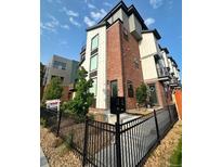 Modern townhome featuring brick accents, black metal railings and a manicured front yard at 5423 S Prince St # B, Littleton, CO 80120