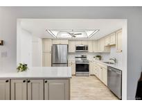 Bright kitchen boasts stainless steel appliances, a ceiling fan, and neutral color palette at 14300 E Marina Dr # 306, Aurora, CO 80014