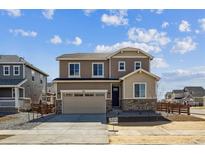 Two-story home featuring mixed siding, stone accents, a two-car garage, and well-maintained landscaping at 833 Alpine Ridge St, Erie, CO 80516