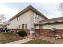 Tan two-story condo building with brick base and landscaping at 9255 E Lehigh Ave # 211, Denver, CO 80237