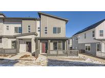 Modern two-story townhome with gray siding, private patio, and walkway at 14586 W 91St Ave # A, Arvada, CO 80005