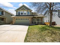 Charming two-story home with a manicured lawn, stone accents, and an attached two car garage at 2602 E 145Th Ave, Thornton, CO 80602