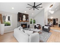 Bright living room with fireplace, ceiling fan, and view into dining room at 4505 S Yosemite St # 362, Denver, CO 80237