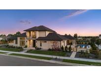 Stunning exterior view of a modern two-story home with a pool and landscaped front yard at dusk at 14545 Lipan St, Westminster, CO 80023