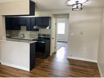 Bright kitchen features stainless steel appliances, modern lighting, and a convenient breakfast bar at 5875 E Iliff Ave # 203, Denver, CO 80222
