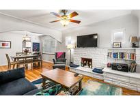 Cozy living room featuring a decorative fireplace, ceiling fan, and ample natural light at 706 S Lincoln St, Denver, CO 80209